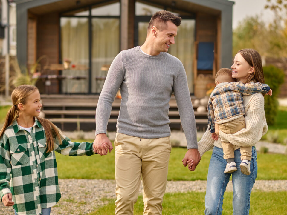 Happy family holding hands walking in yard
